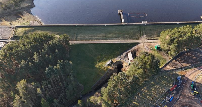 Aerial view of a dam surrounded by forested areas