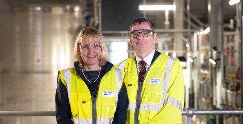Alex Plant and Deirdre Michie in WTW Two people smiling inside large building with pipework infrastructure