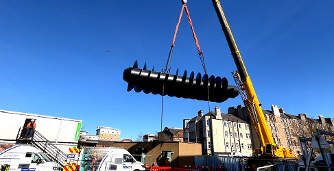 Hoisting the screw pump The screw pump is shown being hoisted into position by a large crane