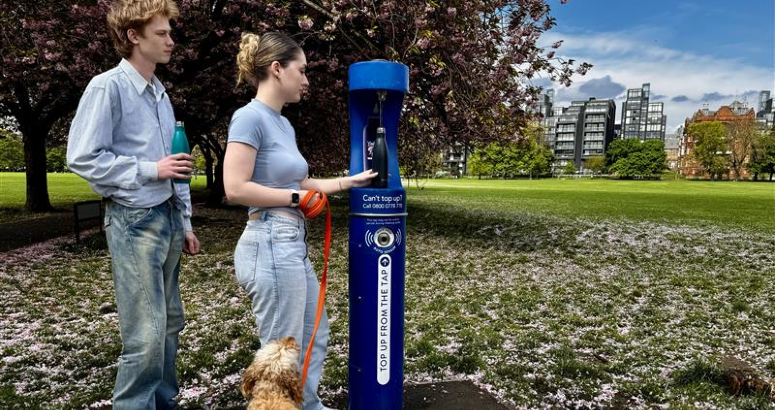 TUT with dog People refilling their bottle with water from a Top Up Tap