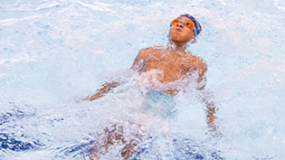 Drowning Prevention Week 2025 Child floating on its back in a swimming pool