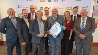 2025 Scottish Civil Engineering Awards  Group of nine people posing with an award at an event. Some are smiling and holding a certificate and a trophy. The setting suggests a professional or corporate event.