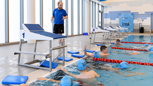 Teacher teaching kids to swim in pool