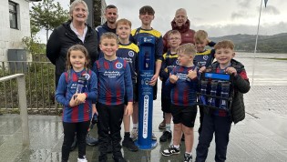 Group of adults and children posing behind brand new water refill station Group of adults and children posing behind brand new water refill station