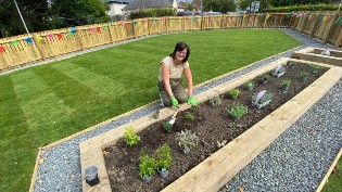 Charlotte Chiswick, Redhall School Head Teacher shown carrying out gardening work in new space.