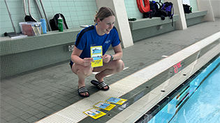 LTS teaching tool launched Learn to Swim teacher Caitlin Ebbage holds up new teaching cards tool at poolside