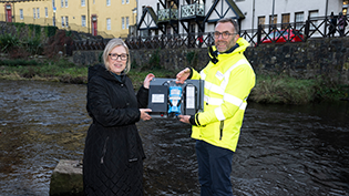 1000 EDM Monitors Launch Cabinet Secretary Gillian Martin and Professor Simon Parsons hold an Event Duration Monitor at Water of Leith, Stockbridge, Edinburgh